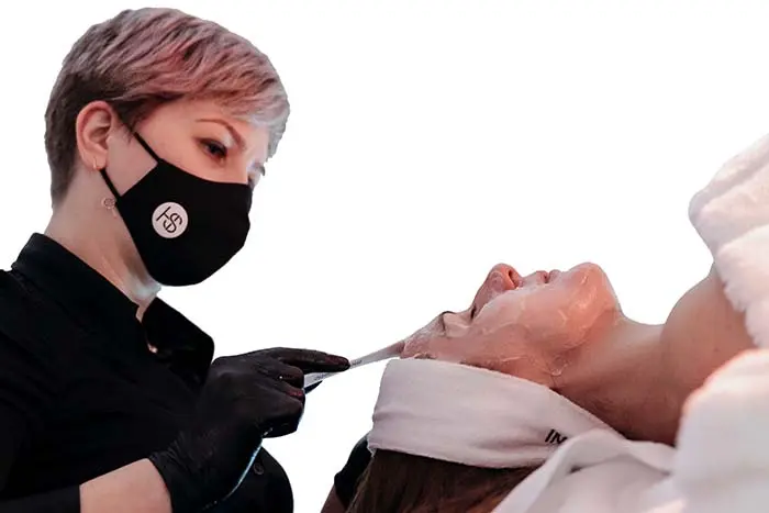 Helena Sas realizando un tratamiento facial con mascarilla sobre una paciente recostada