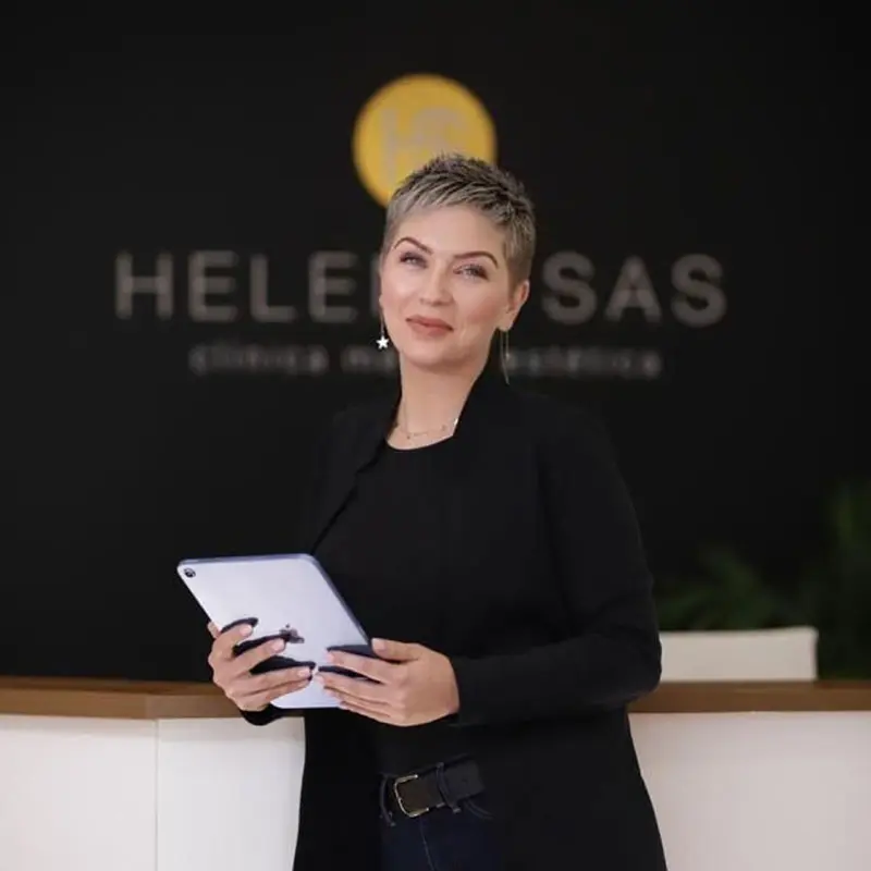 Imagen corporativa Helena SAS y productos estéticos Mujer profesional de Helena SAS posando con tablet frente al logo de la clínica estética
