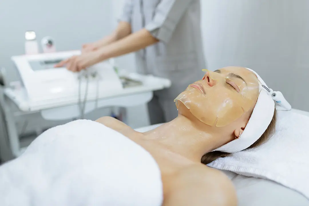 Mujer recibiendo tratamiento facial con mascarilla en clínica estética de Valencia